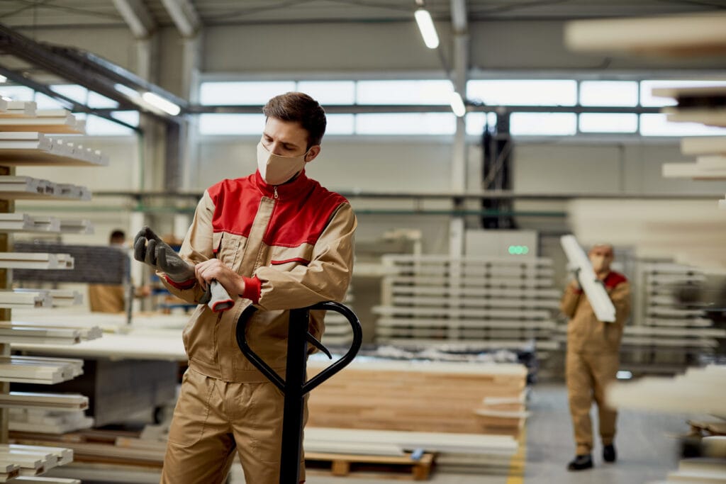 homem trabalhando na produção com luva de trabalho